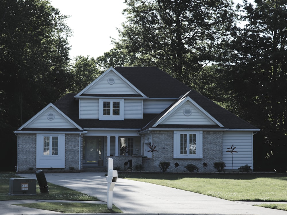 Two-story home with clean white siding and brick after a soft wash
